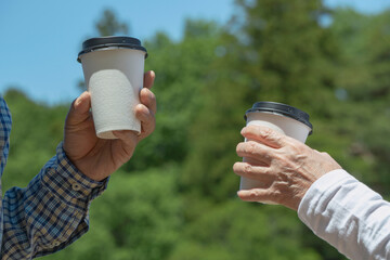 Middle-aged or elderly couples taking drinks in nature....