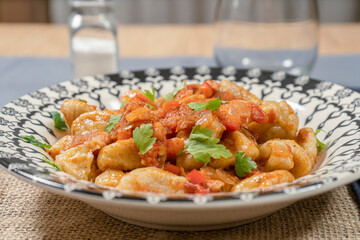 Homemade Italian Gnocchi with Red Sauce served on a decorated plate.