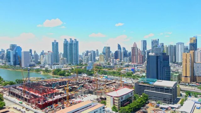 Time-lapse of Queen Sirikit National Convention Centre construction site near Benjakitti Park and Lake, Millenium Residence Apartment, CTI Tower, Ocean Tower in Bangkok, cloudscape on a sunny day