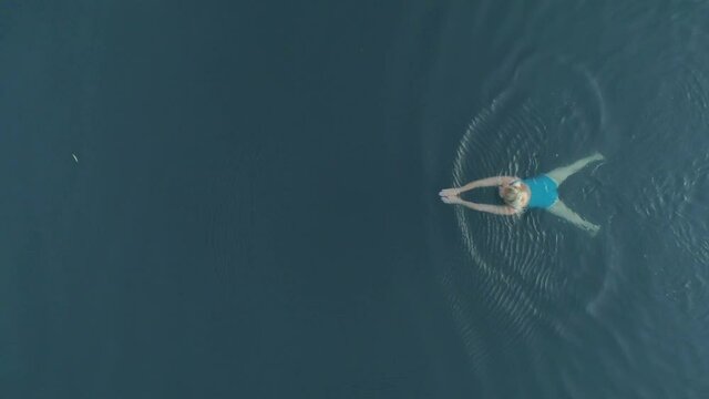 Aerial drone shot of wonderful Lake H&eacute;v&iacute;z at sunrise with woman swimming in the water