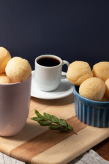 Delicious cheese breads (pão de queijo) and coffee on cutting board.