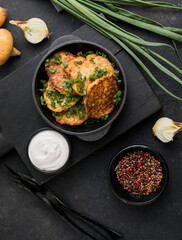 Delicious onion  fritters with sour cream and green onion on plate, closeup