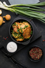 Delicious onion  fritters with sour cream and green onion on plate, closeup