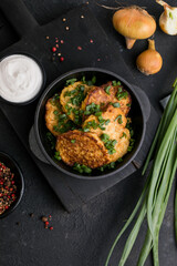 Delicious onion  fritters with sour cream and green onion on plate, closeup