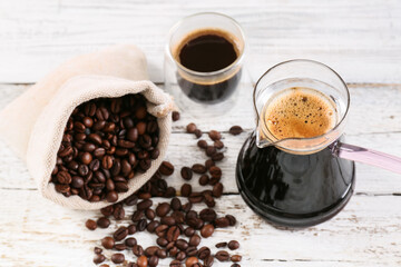 Pot and cup with delicious turkish coffee and bag with beans on light wooden background