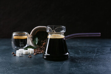 Pot and cup with delicious turkish coffee on dark background