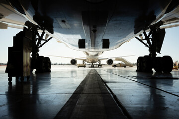 Fototapeta na wymiar Underside and landing gear of a widebody commercial airplane in a hangar.