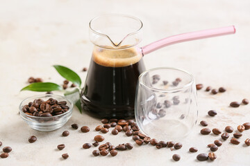 Pot with turkish coffee and beans on light background