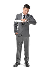 Young businessman with newspaper looking at wristwatch on white background