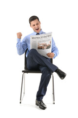 Happy young man reading newspaper on white background