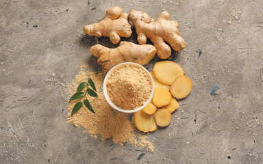 Bowl with ginger powder on grunge background