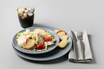 Plate of tasty Caesar salad on light background