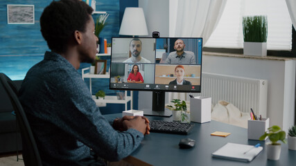 Black man on online internet conference chat with his coworkers, remote working from home, using teleconference web communication with webcam. Distance technology talking