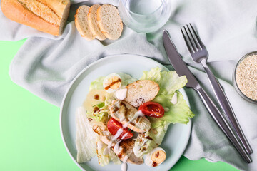 Plate with delicious Caesar salad on color background