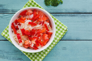 Bowl with tasty sauerkraut on color wooden background