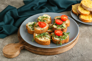 Plate with tasty toasts on grunge background