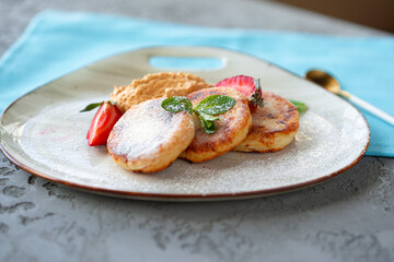 Cottage cheese pancakes with strawberry and sugar powder