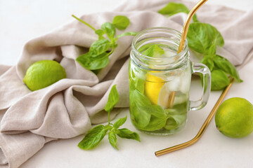 Mason jar of lemonade with basil on light background