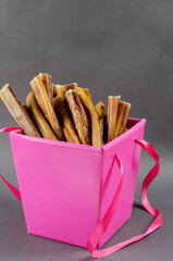 Beautiful pink gift box with pet treats. Open box full of bully