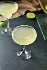 Glasses with tasty daiquiri cocktail on dark background