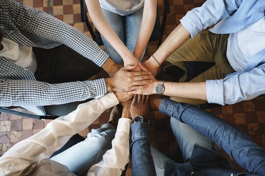 Top view of diverse people hands holding together in circle, hands stack