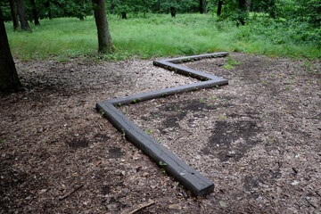 zigzag on the ground in the forest is installed wooden beam for children and athletes, as a training of physical stability, is part of the training ground