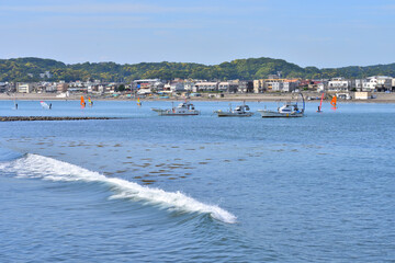 Obraz premium 鎌倉和賀江島に停泊する漁船とウインドサーフィン