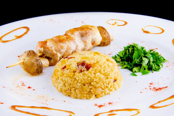 Chicken skewer: Chicken fillet, bell pepper, mushrooms, spicy couscous with vegetables and dried tomatoes with parsley