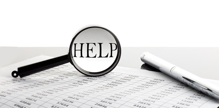 Magnifying glass with text HELP on the background with pen