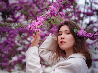 Fototapeta premium beautiful young asian woman enjoying the blooming of flowers in spring