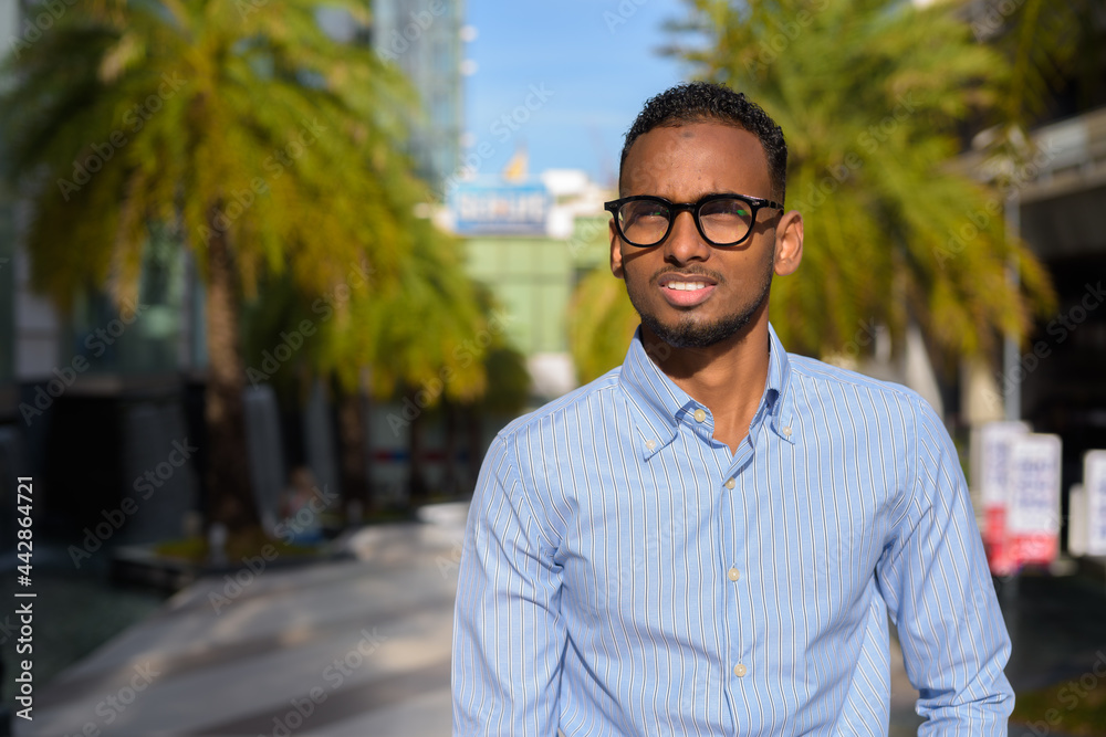 Wall mural portrait of handsome black african businessman outdoors in city during summer