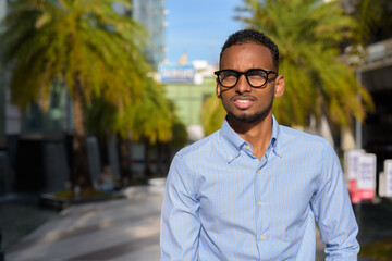 Obraz premium Portrait of handsome black African businessman outdoors in city during summer