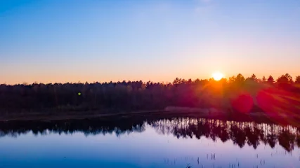 Papier Peint photo Lavable Réflexion Aerial view of a beautiful and dramatic sunset over a forest lake reflected in the water, landscape drone shot. Blakheide, Beerse, Belgium. High quality photo