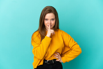 Teenager girl over isolated blue background showing a sign of silence gesture putting finger in...