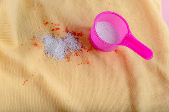 Stain on clothes. washing powder in a plastic spoon. removal of stains from spilled drink. dry cleaning concept