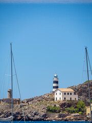 Lighthouse, entrance to the harbor at Port de Soller, Majorca, Balearic Islands, Spain. Sailing, navigate and yachting in the mediterranean sea. Sailboats and fisherman town waterfront