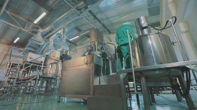 A worker at a pharmaceutical factory. Modern cosmetics production. Industrial interior