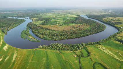 Aerial view of bending river with green banks in summer day. Nature landscape of Desna river in Ukraine