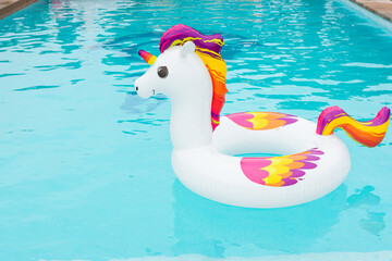 inflatable float in the shape of a colorful unicorn in the pool © pedro
