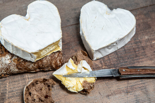 French Neufchatel cheese shaped heart on  wooden background