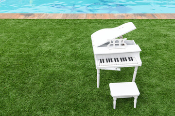 small white piano for children outdoors on artificial grass
