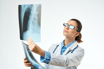 a radiologist in a white coat examines x-rays treating a patient