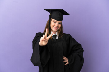 Young university graduate over isolated purple background smiling and showing victory sign