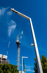 Modern abstract streetlights and cranes against blue sky