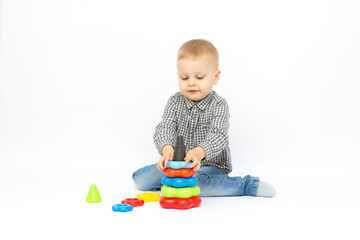 baby on a white background plays with a pyramid