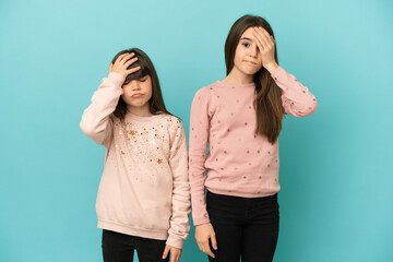 Little sisters girls isolated on blue background with surprise and shocked facial expression