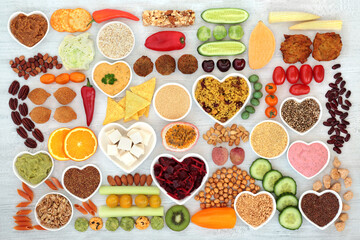 Vegan food for a healthy planet with plant based health foods high in antioxidantsm, anthocyanins, fibre, vitamins, minerals, lycopene & smart carbs. Ethical eating concept. Flat lay on rustic wood.