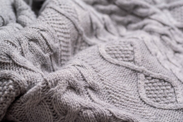 A fragment of a knitted plaid close-up of gray color. 