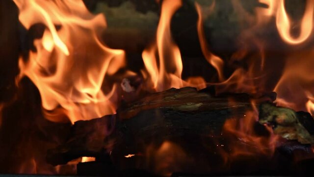 Burning fire in stone fireplace mantel close up video. Burning wood in the fireplace. Slow motion.