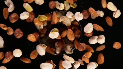 Rotating Various Nuts on Black Background. Top Shot.